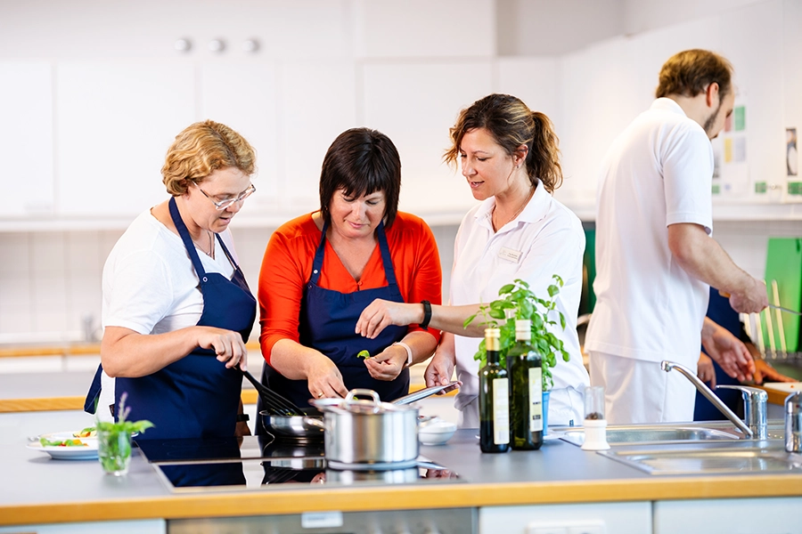Drei Frauen kochen in der Lehrküche der Reha-Klinik Göhren.