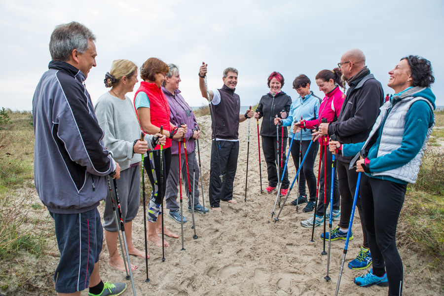 Eine Patientengruppe beim Nordic Walking am Strand