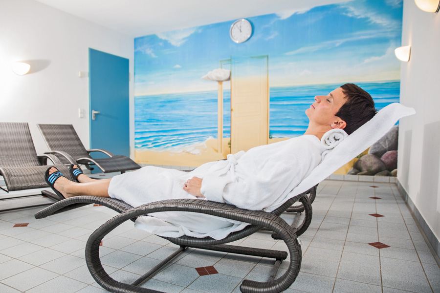 Eine Frau entspannt im Ruheraum der Reha-Klinik Göhren
